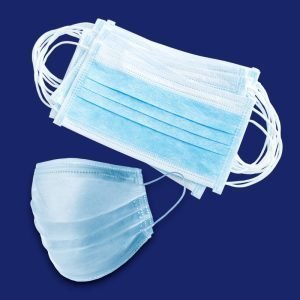 A bundle of light blue disposable surgical face masks with white elastic ear loops, laid flat on a dark blue background, with one mask positioned upright to show its pleated, contoured shape.